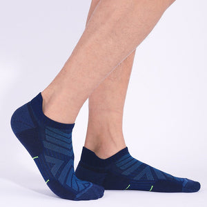 Close-up of a person wearing dark blue sports socks with geometric patterns and green highlights.