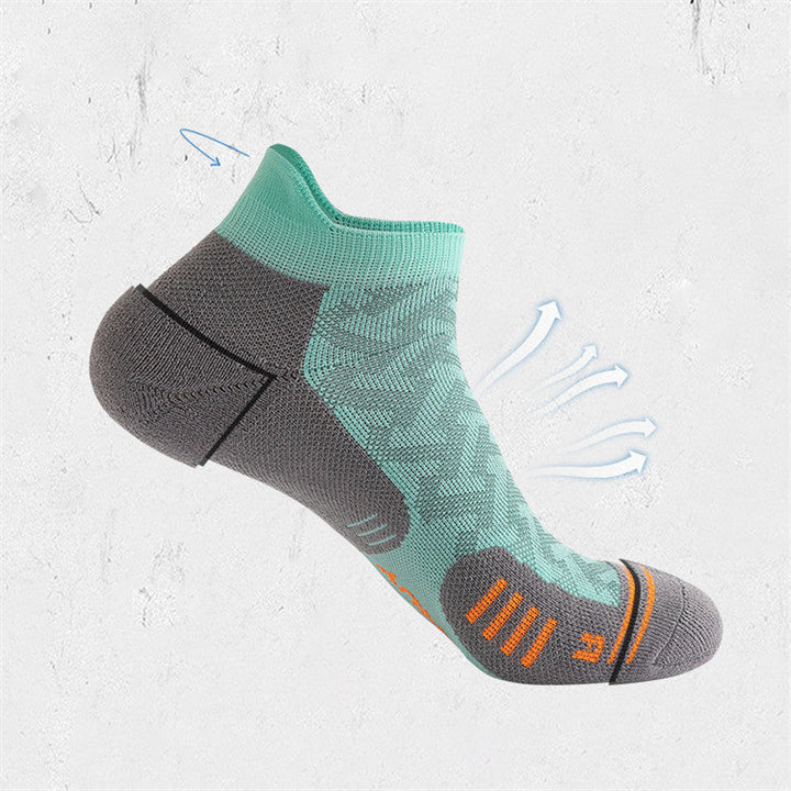 Single mint green ankle sock with grey toe and heel support, featuring dynamic orange stripes, displayed in an artistic style with drawn motion lines.