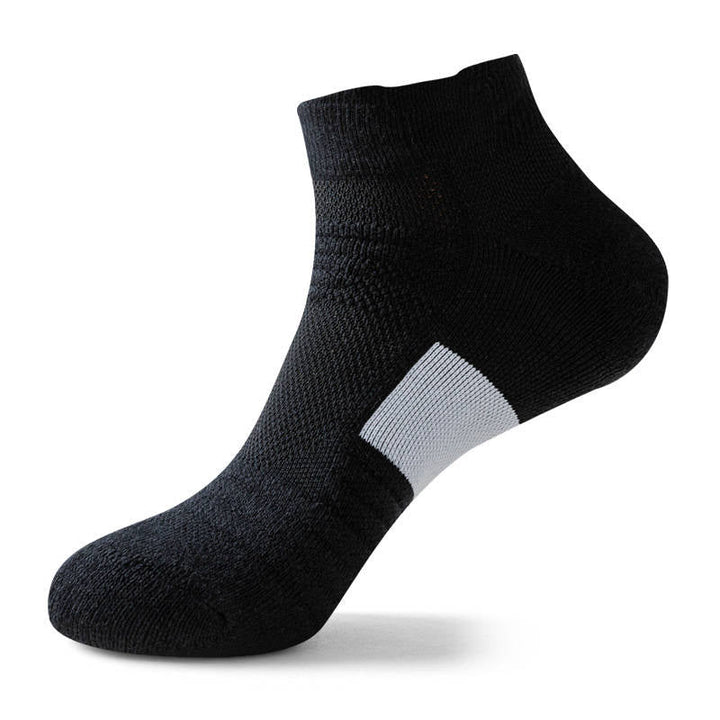 Black ankle sock with a white patch on the foot arch, isolated on a white background.