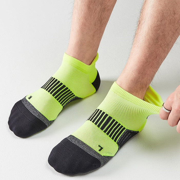 A person adjusting lime green and black ankle socks with stripe design.