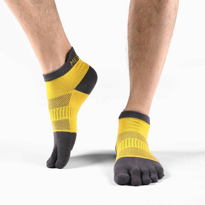 Person standing in yellow and black toe socks with arch support.