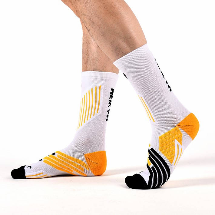 Person walking in white athletic socks with vibrant yellow patterns and black details.